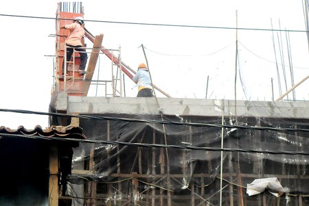 Workers atop a building without safety belts. (Photo:SGGP)